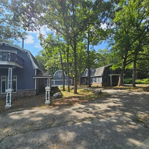 a view of a house with a yard and large tree