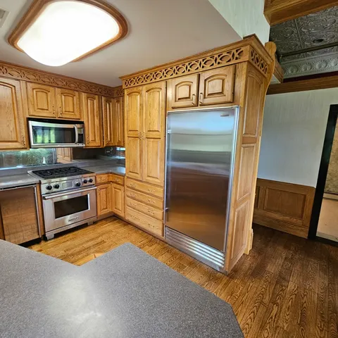 a kitchen with stainless steel appliances granite countertop a stove a sink and a refrigerator