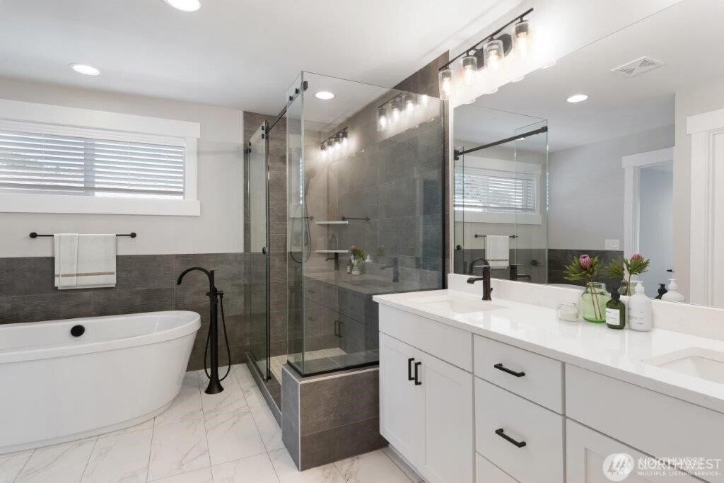 7544 South 129th Street Seattle, WA 98178 - Photo 8 of 9 a bathroom with a double vanity sink a toilet a mirror and bathtub