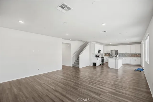a view of a kitchen with wooden floor and electronic appliances