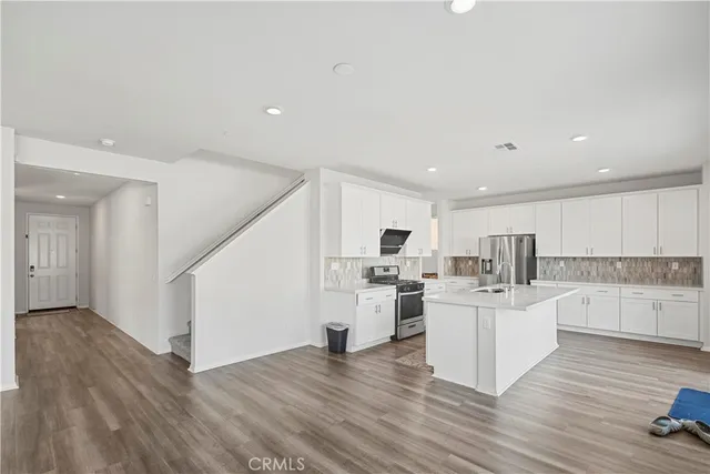 a kitchen with stainless steel appliances granite countertop a stove and a refrigerator