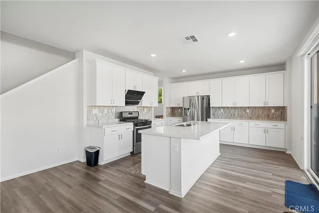 a large white kitchen with cabinets