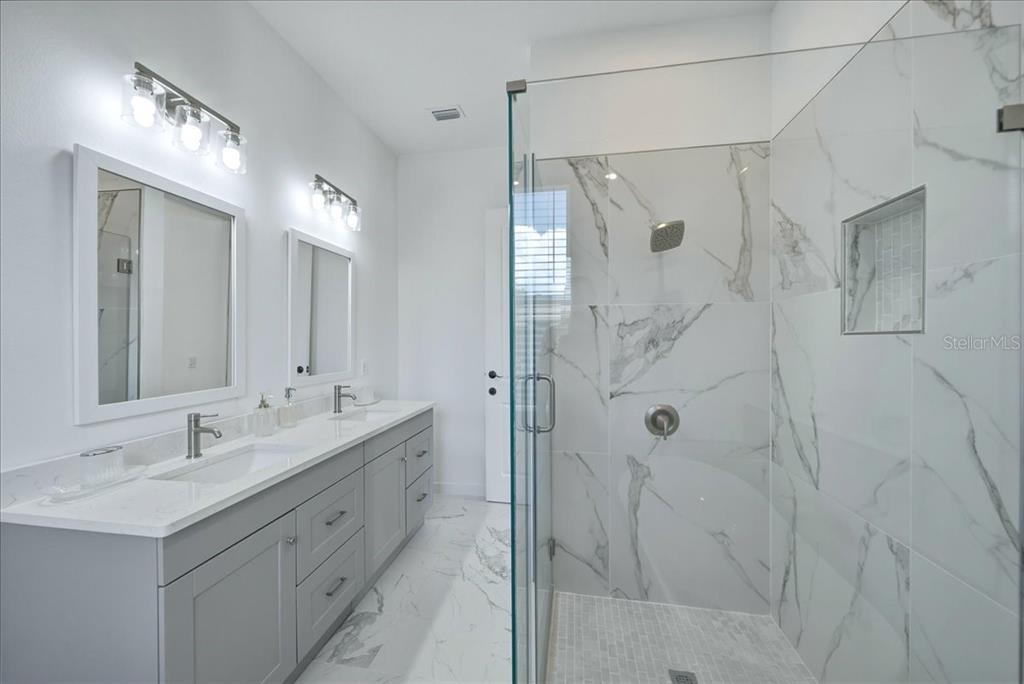 1215 Rio De Janeiro Avenue Punta Gorda, FL 33983 - Photo 44 of 65 a bathroom with a double vanity sink mirror and shower