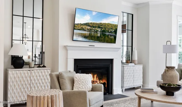 a living room with furniture a flat screen tv and a fireplace
