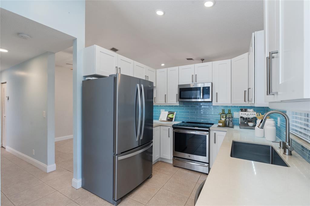 3240 Northwest 106th Avenue Sunrise, FL 33351 - Photo 6 of 21 a kitchen with stainless steel appliances granite countertop a refrigerator and a stove top oven