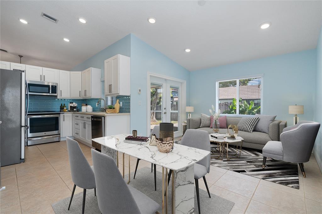 3240 Northwest 106th Avenue Sunrise, FL 33351 - Photo 9 of 21 a living room with stainless steel appliances kitchen island granite countertop a dining table chairs microwave and view kitchen