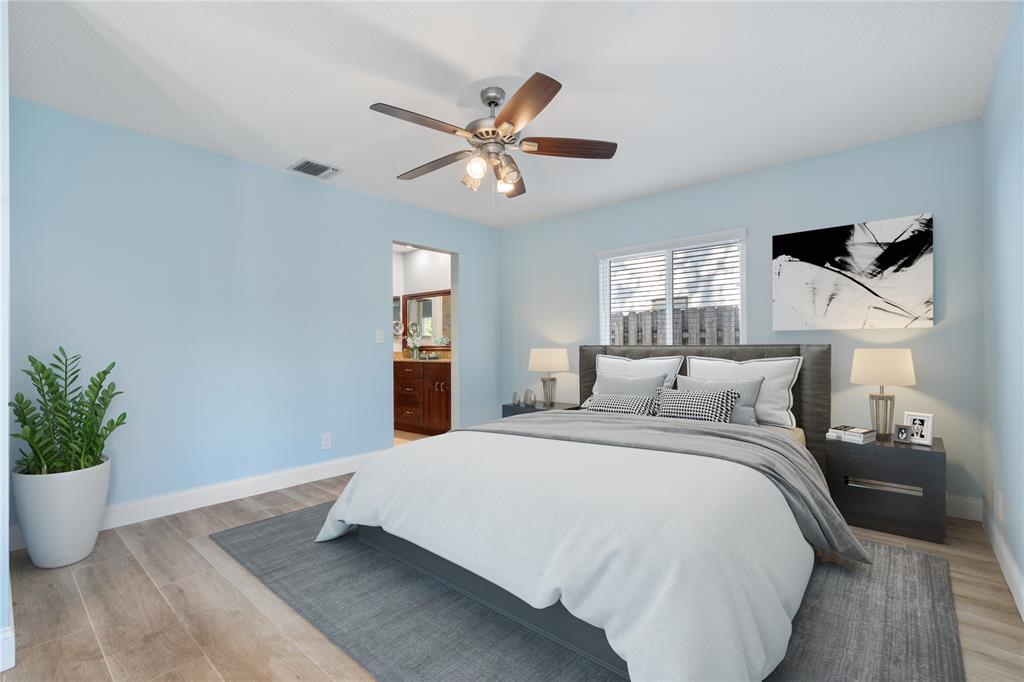 3240 Northwest 106th Avenue Sunrise, FL 33351 - Photo 10 of 21 a bedroom with a large bed and a chandelier