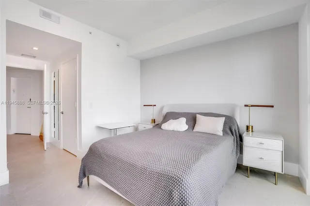 a bedroom with a bed and a painting on the wall