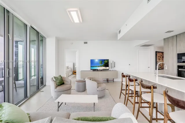 a living room with furniture a flat screen tv and a large window