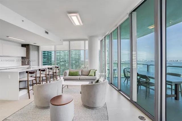 a dining room with furniture and floor to ceiling window