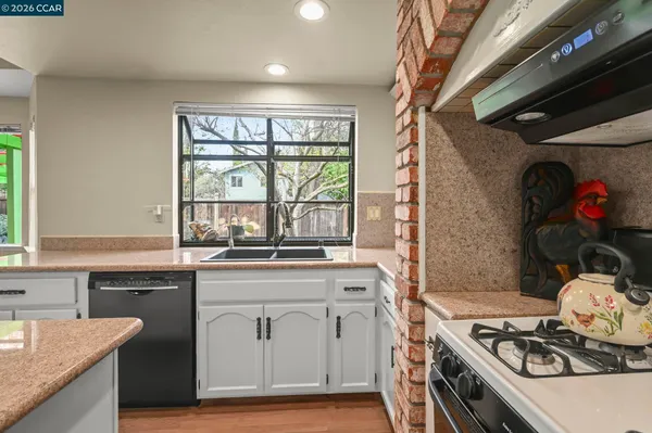 a kitchen with a stove a sink and cabinets