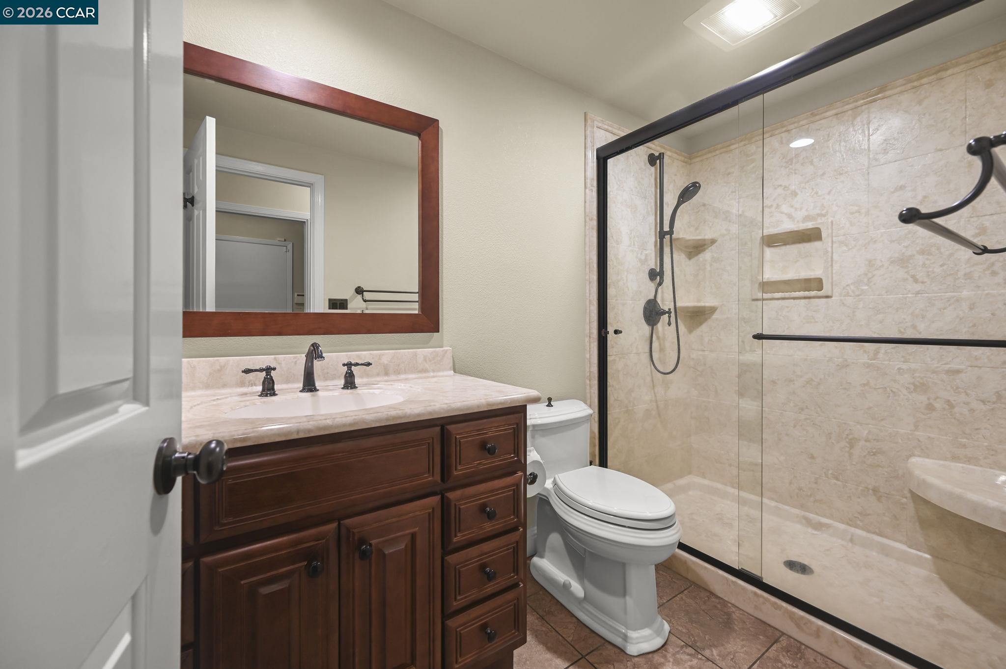 5017 Murchio Drive Concord, CA 94521 - Photo 14 of 30 a bathroom with a granite countertop sink toilet a mirror and shower