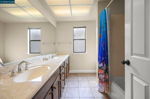 a spacious bathroom with a double vanity sink and a mirror