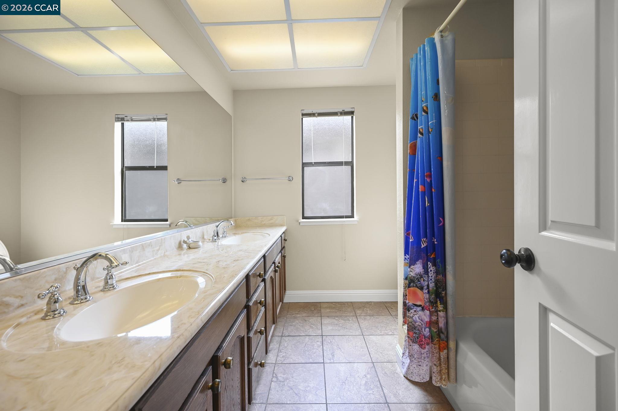 5017 Murchio Drive Concord, CA 94521 - Photo 22 of 30 a spacious bathroom with a double vanity sink and a mirror
