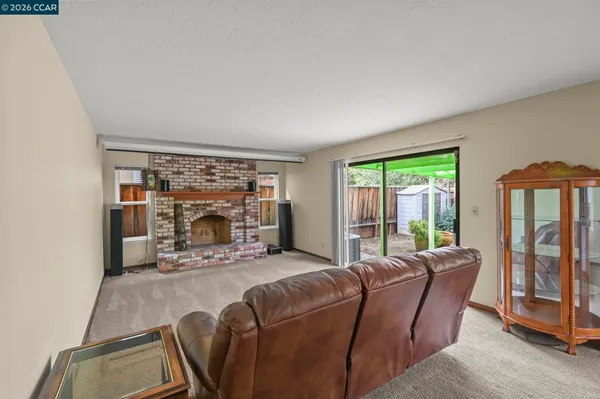 a living room with furniture a floor to ceiling window and a fireplace