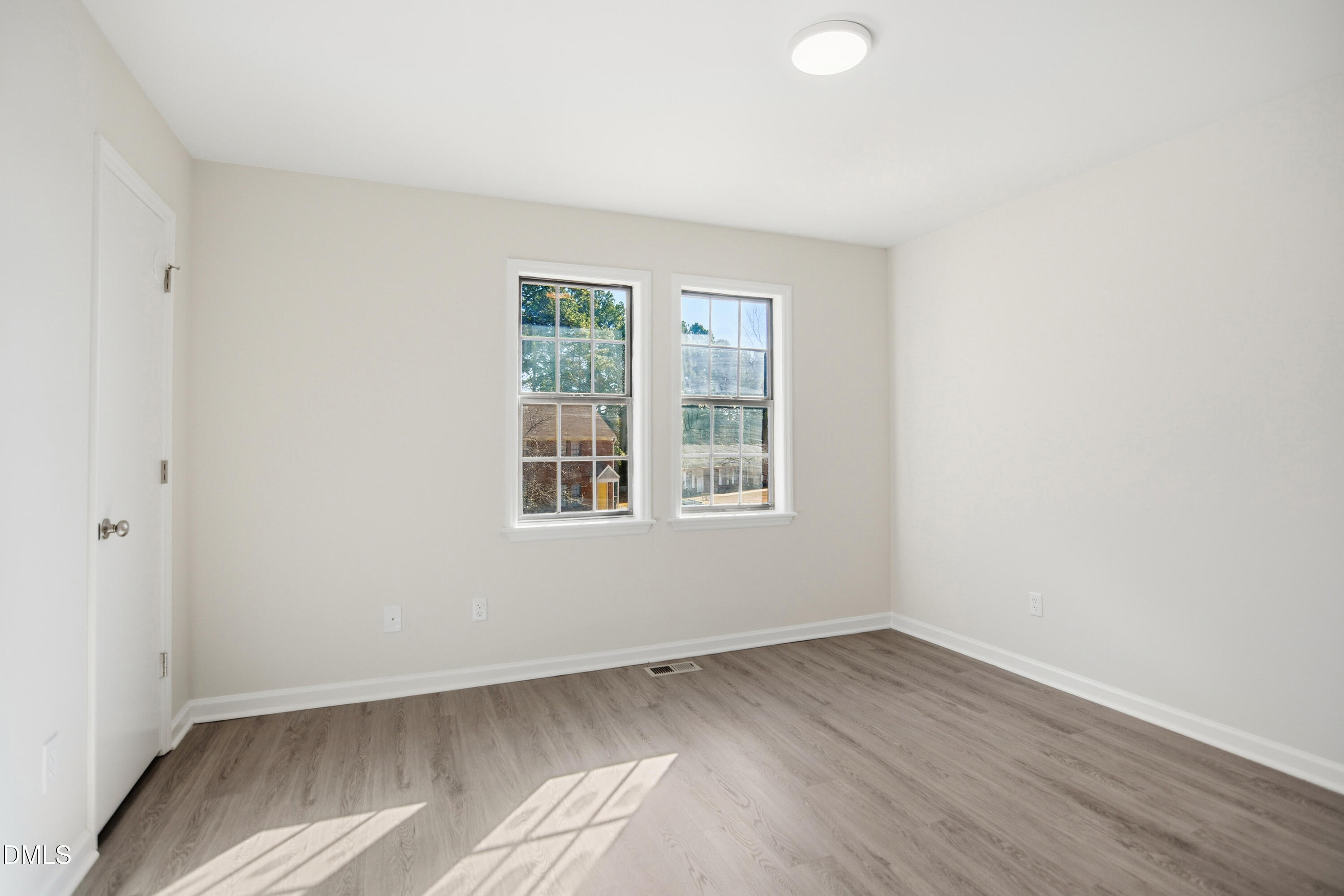 1931 Tischer Road Raleigh, NC 27603 - Photo 13 of 19 an empty room with wooden floor and windows