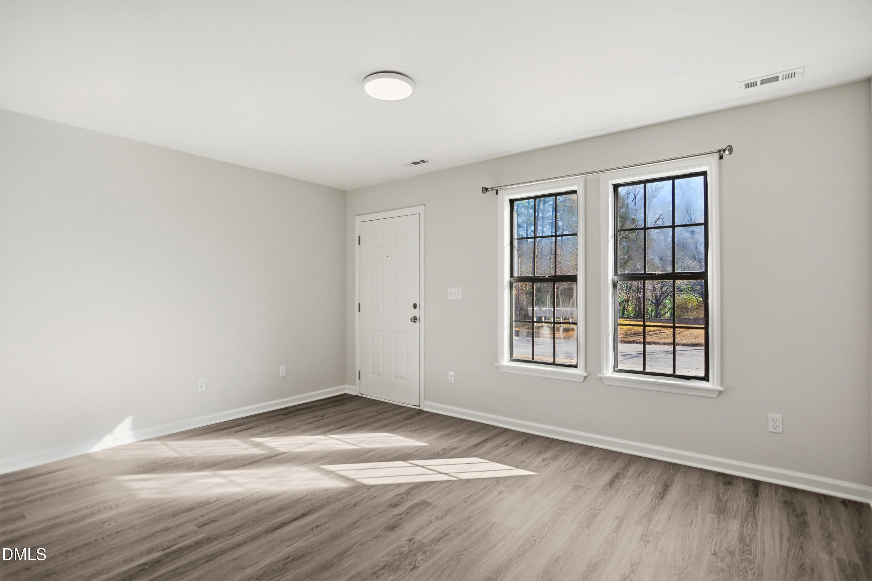 1931 Tischer Road Raleigh, NC 27603 - Photo 3 of 19 an empty room with wooden floor and windows