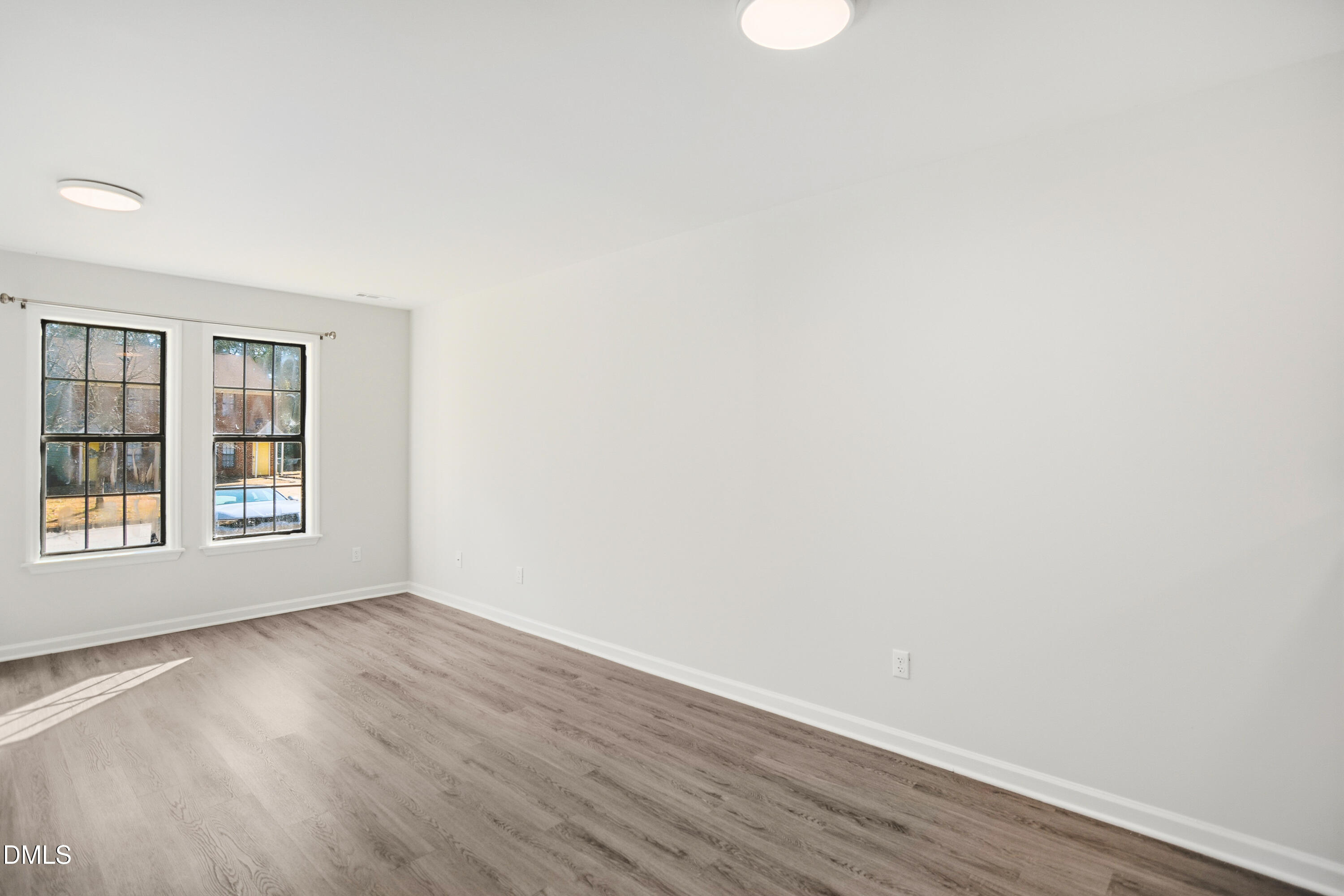 1931 Tischer Road Raleigh, NC 27603 - Photo 5 of 19 an empty room with wooden floor and windows