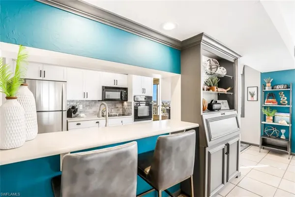 a kitchen with kitchen island a stove a sink and a refrigerator