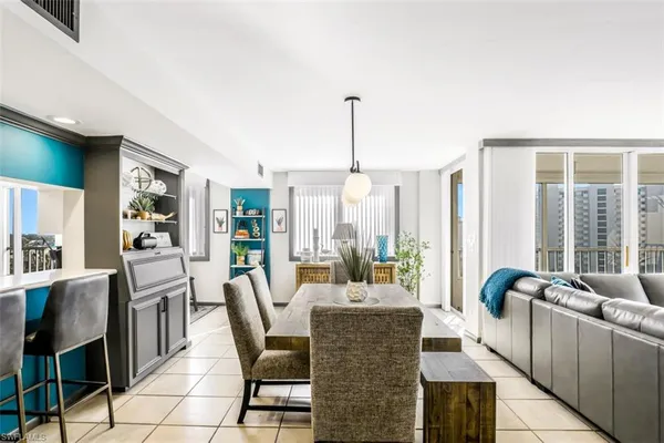 a dining room with furniture and large windows