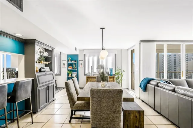 a dining room with furniture and large windows