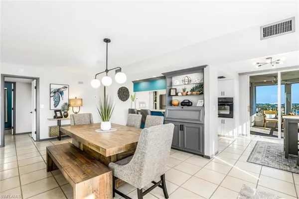 a living room with furniture a dining table and a chandelier