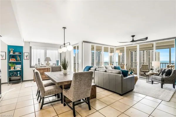 a dining room with furniture and large windows