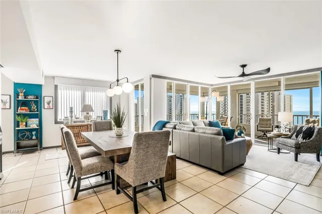 a dining room with furniture and large windows