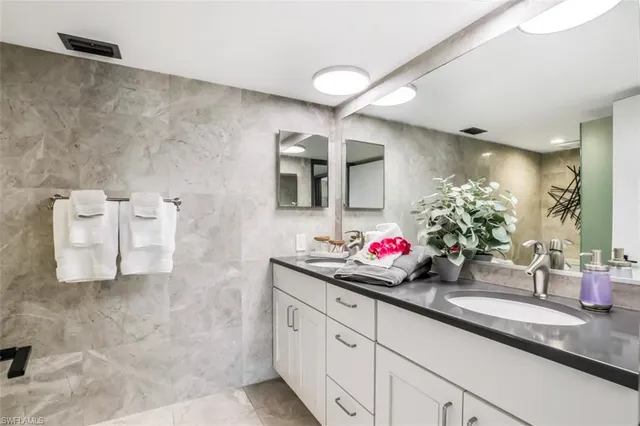 a bathroom with a double vanity sink mirror and shower