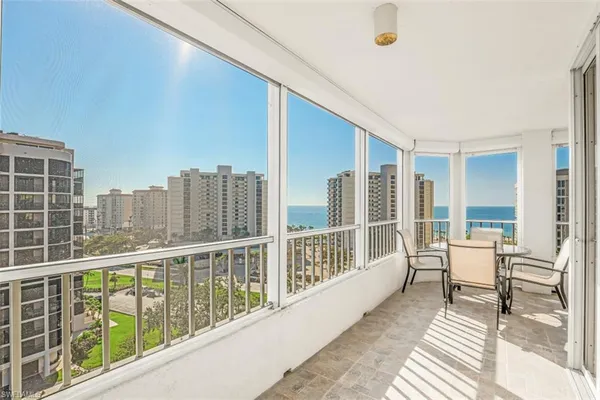 a view of a balcony with table and chairs and wooden fence
