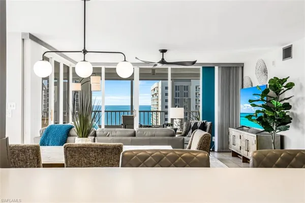 a living room with furniture potted plant and a large window