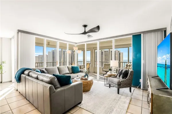 a living room with furniture and floor to ceiling windows