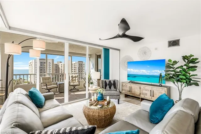 a living room with furniture a chandelier and a large window