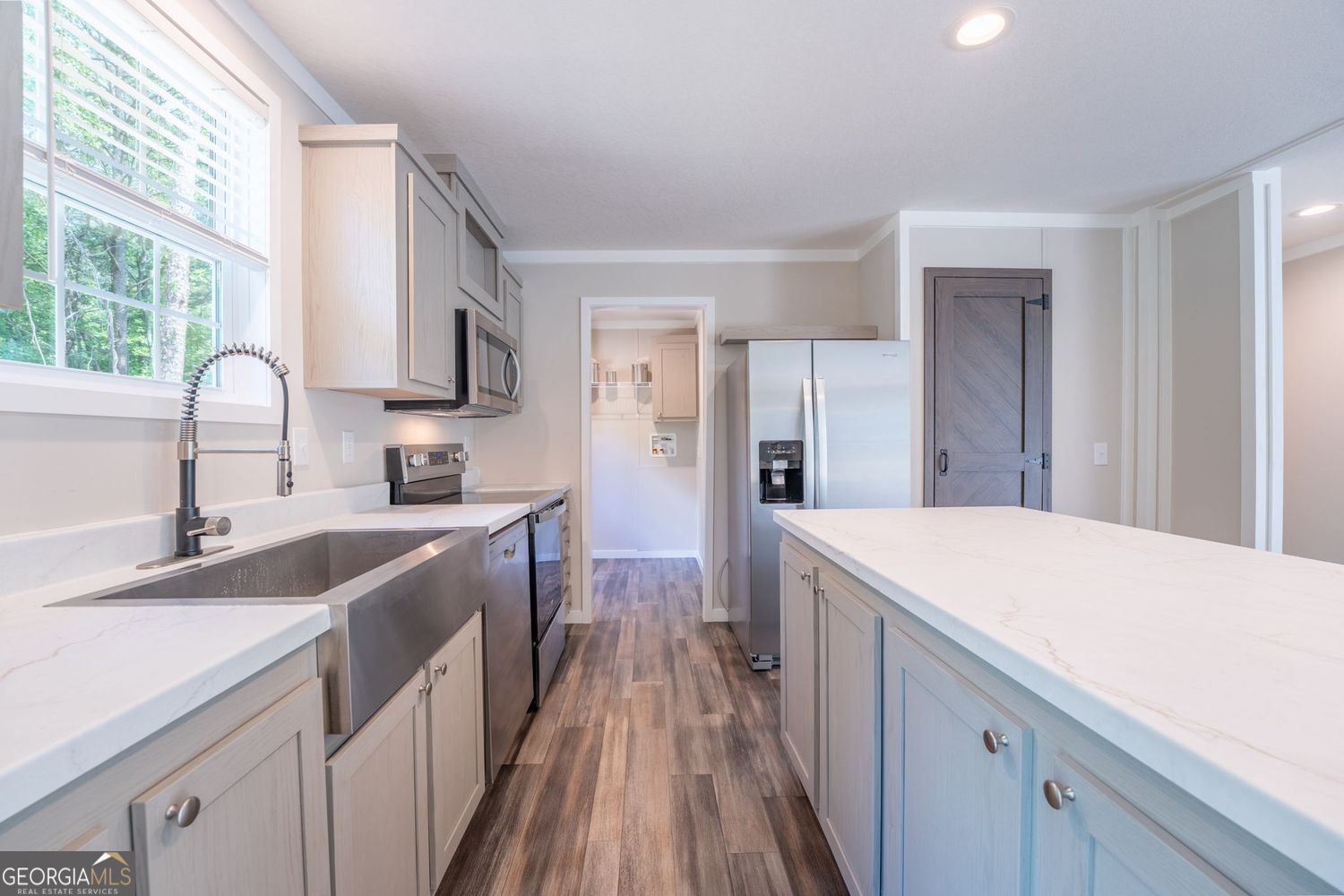 734 Hollywood Church Road Clarkesville, GA 30523 - Photo 13 of 49 a kitchen with a sink a counter top space stainless steel appliances cabinets and a large window