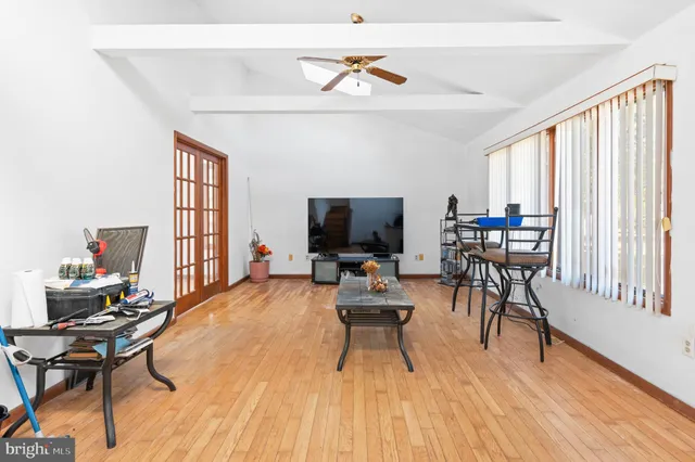 a living room with furniture a rug potted plant and a large window
