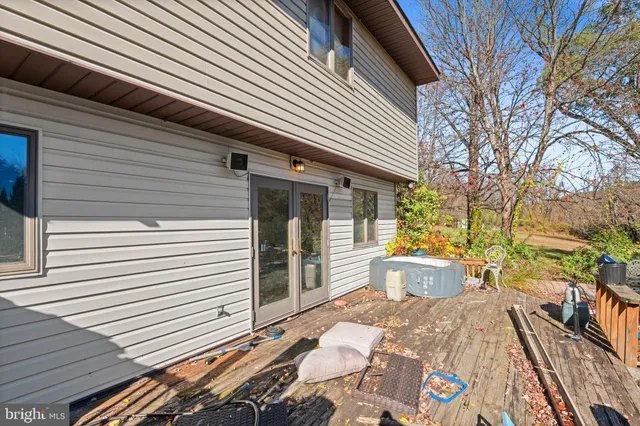 a view of a roof deck with couches and wooden fence