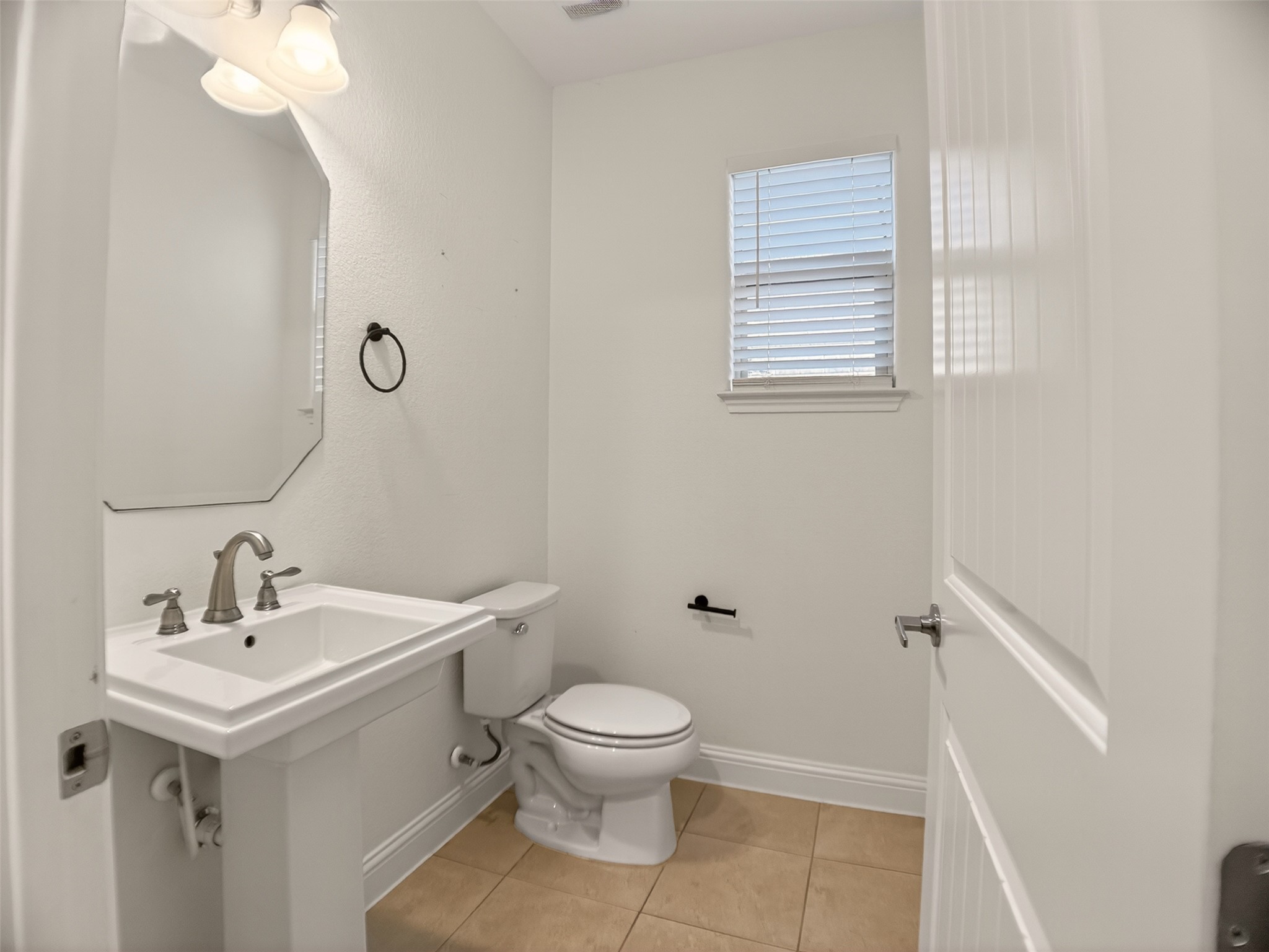 1505 Long Shadow Lane Georgetown, TX 78628 - Photo 7 of 28 Powder room featuring a pedestal sink with a brushed nickel faucet, an octagonal mirror, and a window with blinds