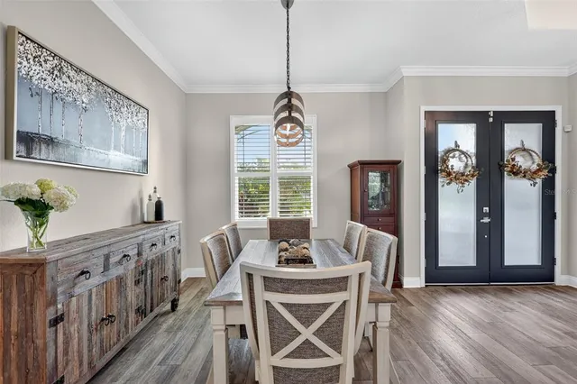 a dining room with furniture window and wooden floor