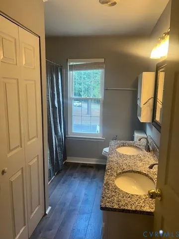 a en suite bathroom with a granite countertop sink and a mirror