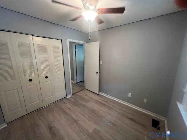 an empty room with closet and a chandelier fan
