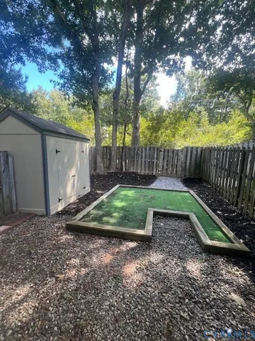 a view of a backyard with plants and wooden fence