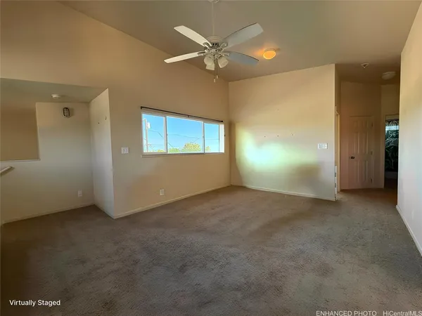 an empty room with windows and fan