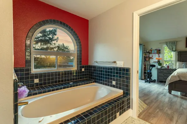 a large white kitchen with stainless steel appliances granite countertop a stove a sink a refrigerator and cabinets