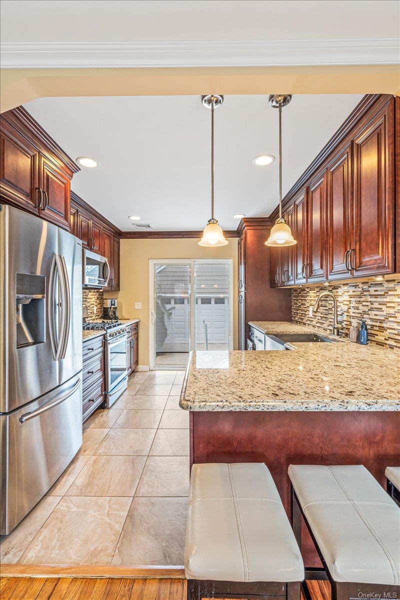 369 Yale Road Garden City, NY 11530 - Photo 5 of 19 Kitchen w/Granite Island, Stainless Steel Appliances, Sliders