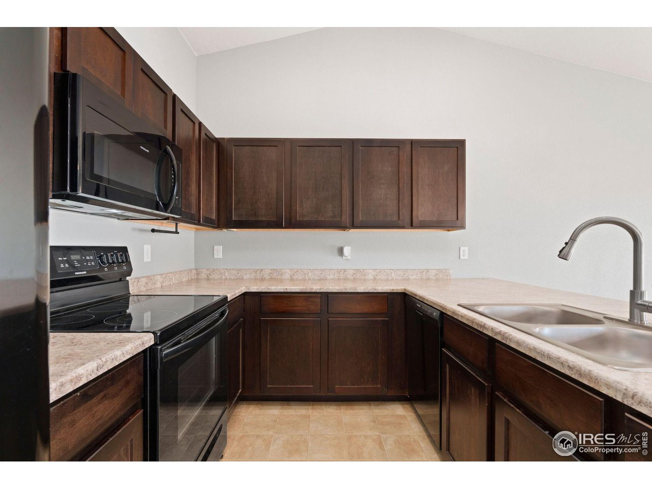 856 Sunlight Peak Drive Severance, CO 80550 - Photo 13 of 40 a kitchen with stainless steel appliances granite countertop a sink stove and microwave