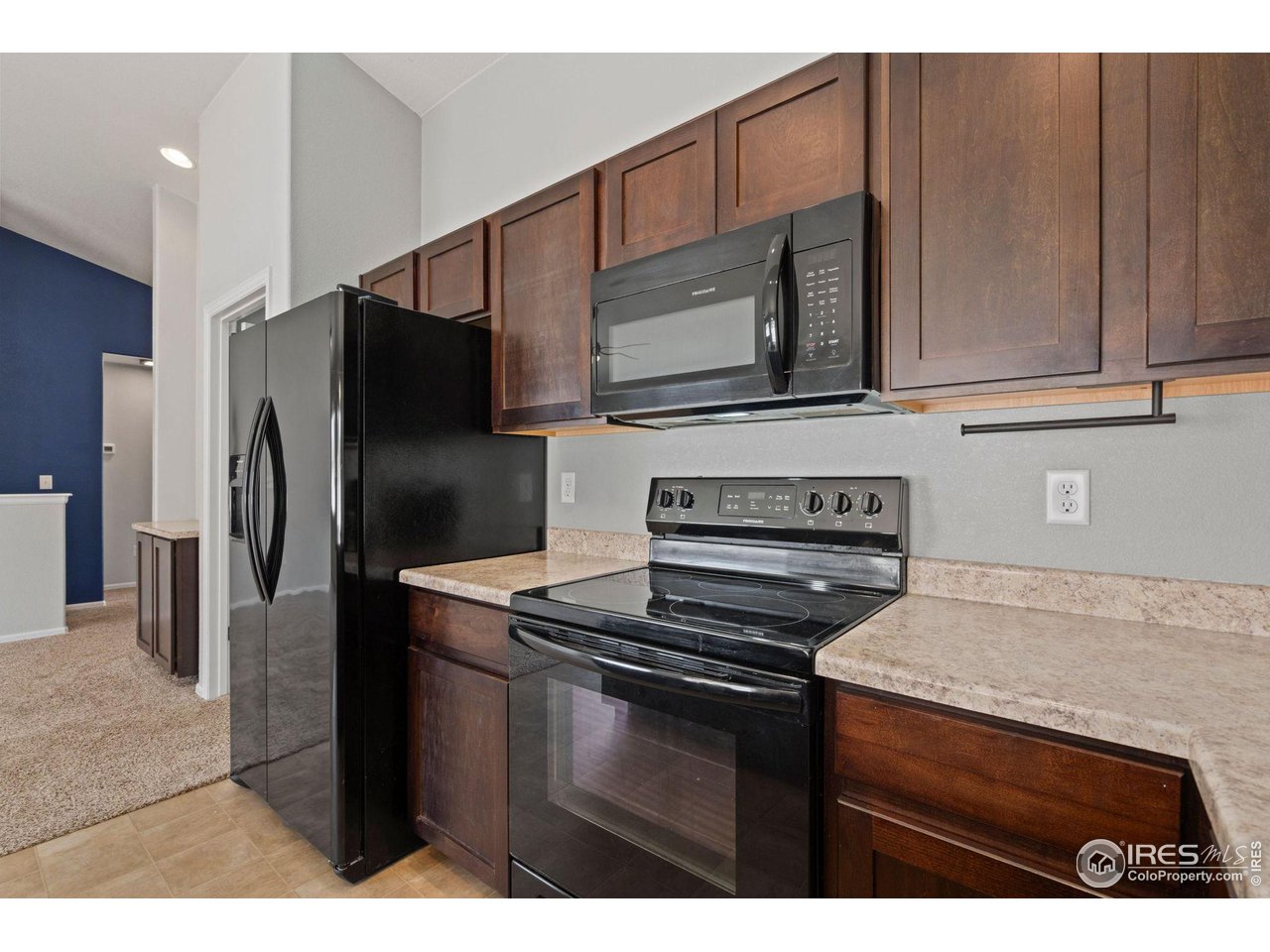 856 Sunlight Peak Drive Severance, CO 80550 - Photo 14 of 40 a kitchen with a refrigerator stove and cabinets