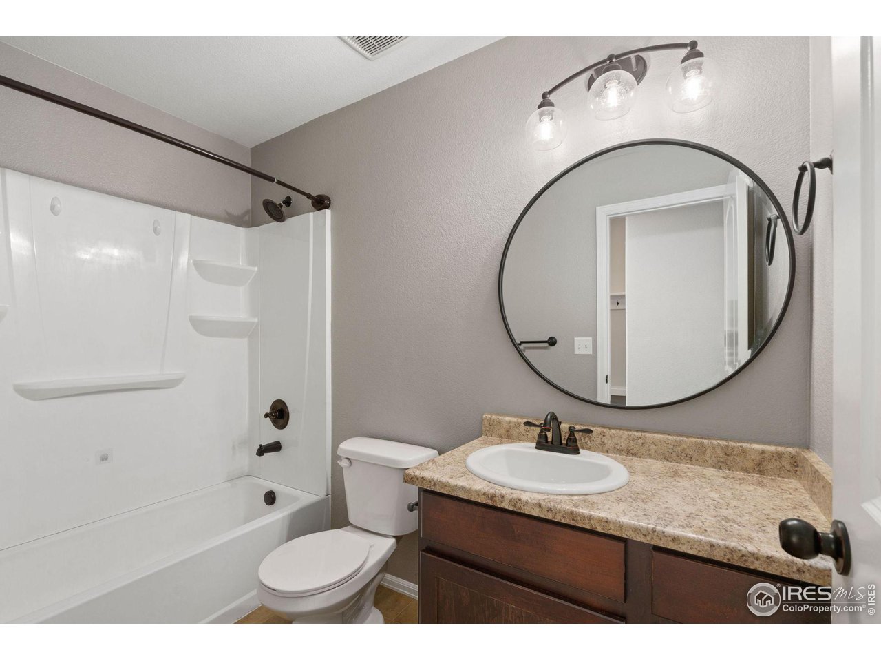 856 Sunlight Peak Drive Severance, CO 80550 - Photo 23 of 40 a bathroom with a granite countertop sink toilet a mirror and shower