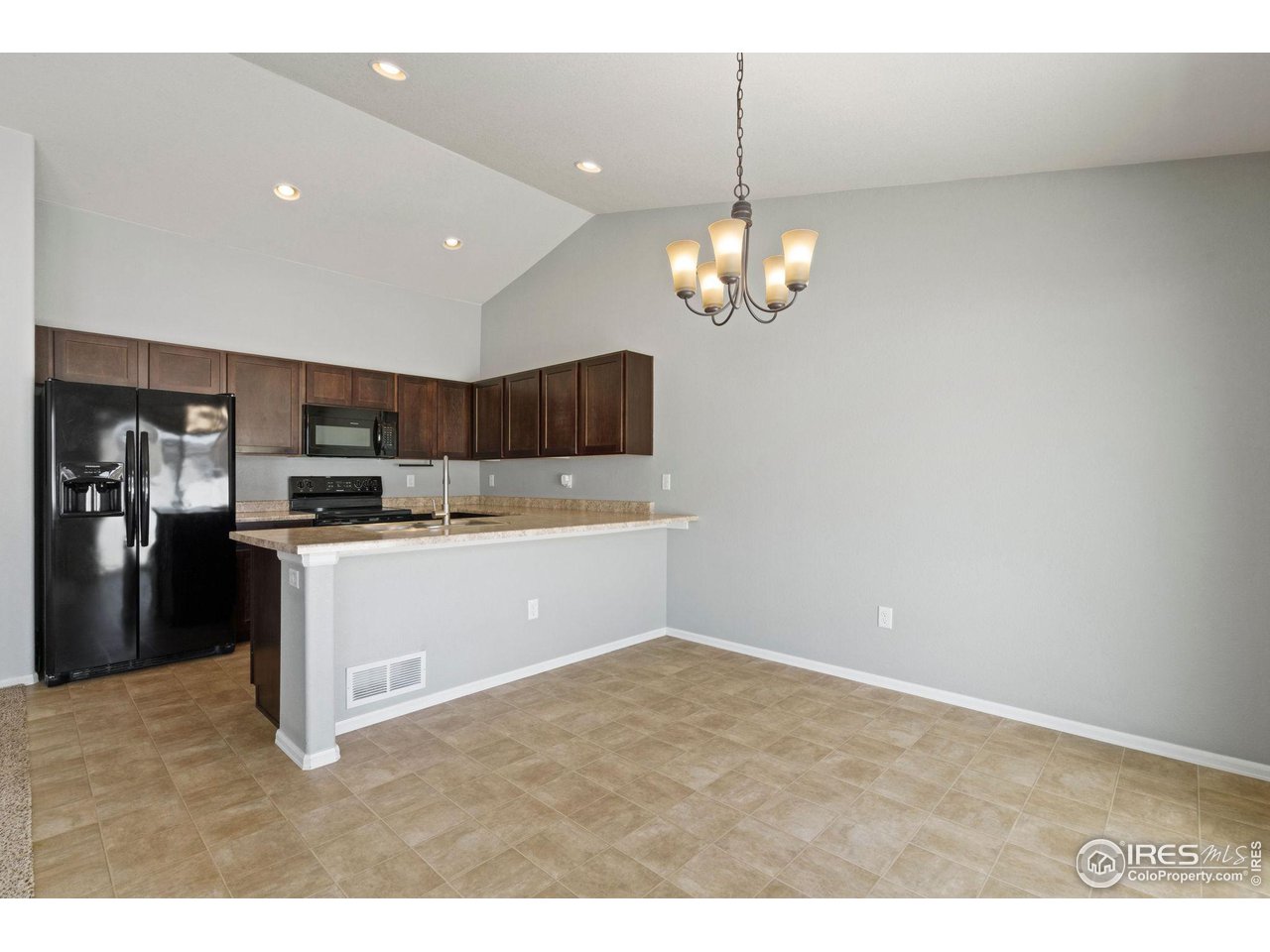 856 Sunlight Peak Drive Severance, CO 80550 - Photo 10 of 40 a kitchen with a refrigerator and chandelier