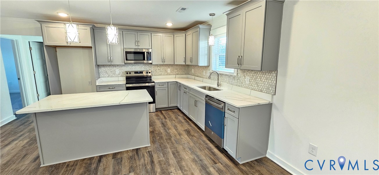1929 Howerton Road Dunnsville, VA 22454 - Photo 4 of 17 a kitchen with a sink a counter top space stainless steel appliances and cabinets