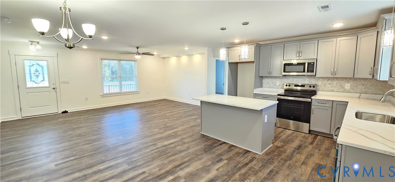1929 Howerton Road Dunnsville, VA 22454 - Photo 7 of 17 a kitchen with stainless steel appliances granite countertop a stove a sink dishwasher a refrigerator and white cabinets with wooden floor